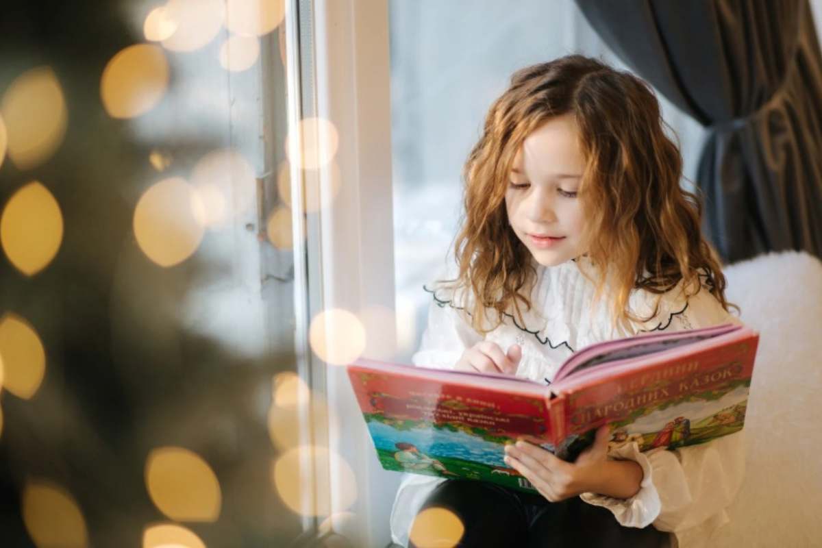 Bambina con un libro illustrato 